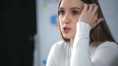 İş toplantısında konuşurken saçına dokunan pozitif iş kadını