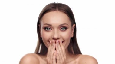 Şok olmuş bir kadın alkış tutuyor ve gülümsüyor.