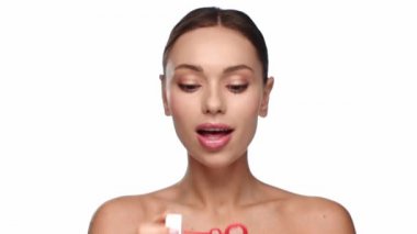 Beyaz sabun köpükleri üfleyen kadın.