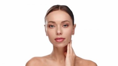 Kadın boynuna dokunuyor ve gülümsüyor.