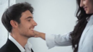 gülümseyen kadın sarılıyor ve iş adamının kravatını tutuyor. 