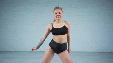 Beyaz arka planda dans eden çekici sarışın kadın.