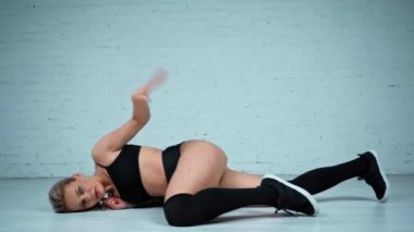 Dans eden ve yerde kıvranan seksi kadın.