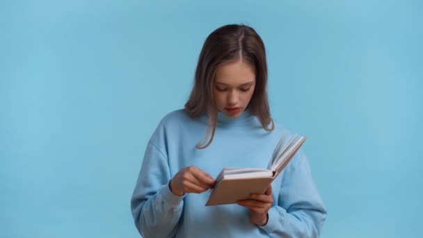 Tense Teenager Reading Book Isolated Blue — Stock Video