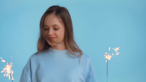 Lachende Tiener Dansen Met Bengaalse Lichten Geïsoleerd Blauw — Stockvideo