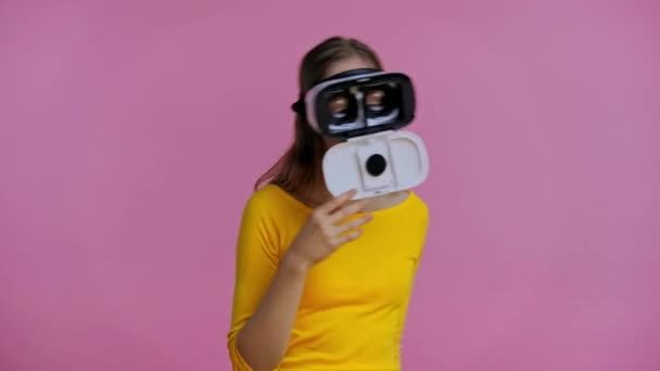 用粉色隔离的虚拟现实耳机跳舞的青少年 — 图库视频影像