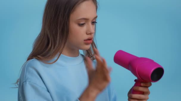 Irritado Adolescente Secagem Cabelo Isolado Azul — Vídeo de Stock