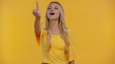 Kadın parmağıyla işaret ediyor, sarı renkte izole edilmiş gibi görünüyor.