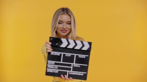 Sonriente Mujer Sosteniendo Clapboard Aislado Amarillo — Vídeos de Stock