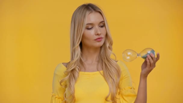 Жінка Вказує Пальцем Пісочний Годинник Ізольовано Жовтим — стокове відео