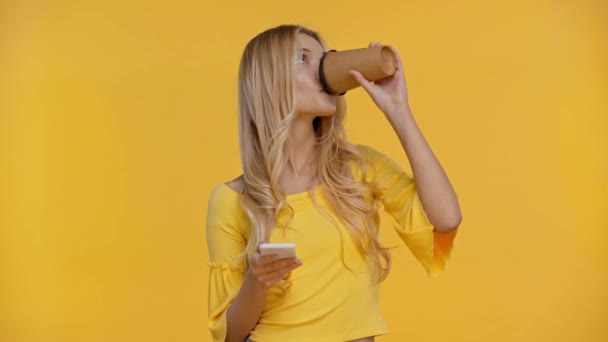 Женщина Пьет Кофе Помощью Смартфона Изолированы Желтый — стоковое видео