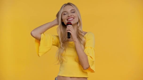 Mulher Sorrindo Falando Com Microfone Isolado Amarelo — Vídeo de Stock
