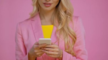 Kırpılan görünümünü pink izole smartphone kullanan kadın