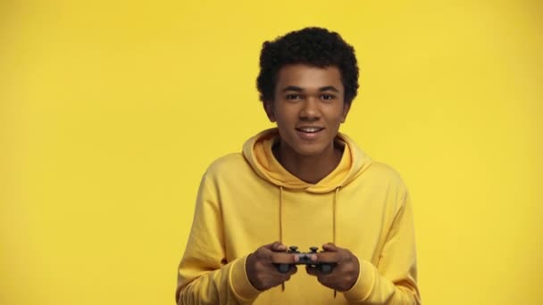 Kyiv ウクライナ 2019年10月18日 アフリカ系アメリカ人のティーンエイジャーが黄色で隔離されたビデオゲームをプレイ — ストック動画
