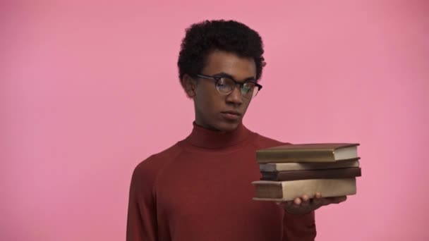 持有用粉色隔离的书籍的非洲裔美国青少年 — 图库视频影像
