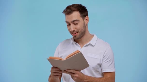 Sonriente Hombre Leyendo Libro Aislado Azul — Vídeos de Stock
