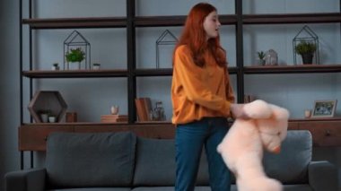 Neşeli genç kız büyük oyuncak ayıyla dans ediyor.