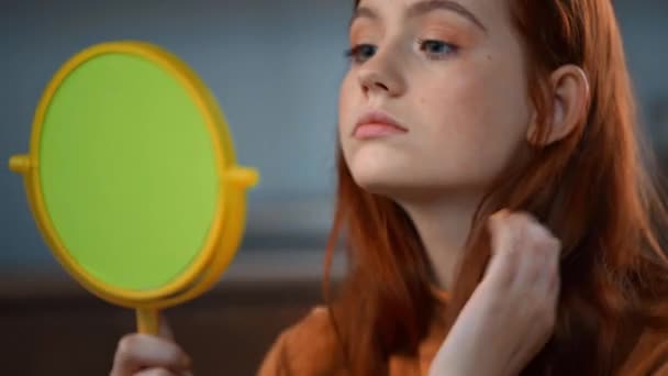 少女看着镜子 摸着脸和头发 — 图库视频影像