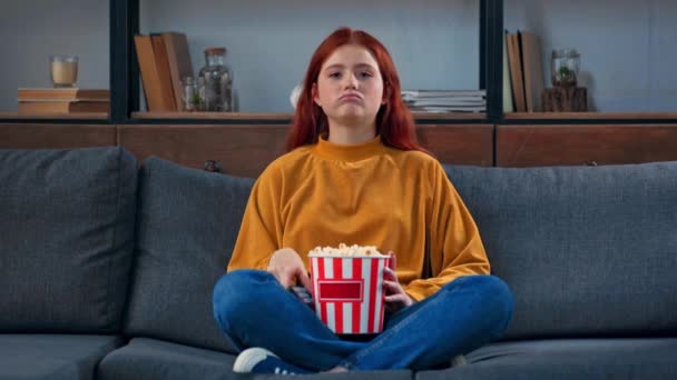 陽気な10代の女の子テレビを見てポップコーンを食べる — ストック動画