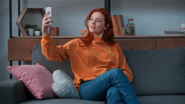 Fröhliches Teenager Mädchen Sitzt Auf Sofa Und Macht Selfie — Stockvideo