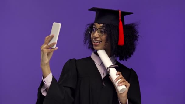 Smiling African American Graduate Taking Selfie Isolated Purple — Stock Video