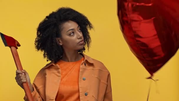 Afrikanerin Hält Luftballon Und Axt Isoliert Auf Gelb — Stockvideo