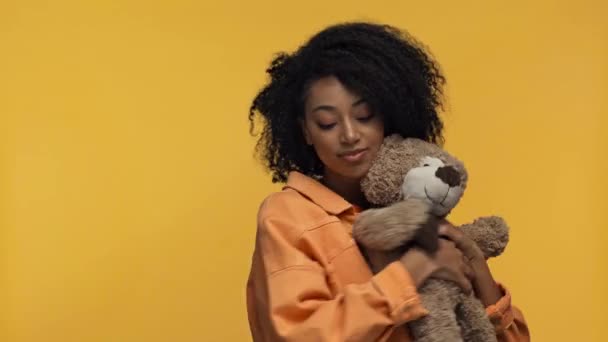 Lächelnde Afroamerikanerin Hält Teddybär Isoliert Auf Gelb — Stockvideo