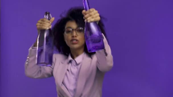 Sorridente Mulher Negócios Afro Americana Dançando Com Garrafas Isoladas Roxo — Vídeo de Stock