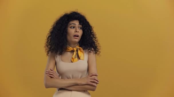 濃い黄色に隔離された失望のジェスチャーを示す動揺二人種間の女性 — ストック動画