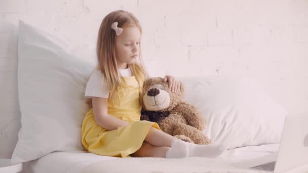 Niño Viendo Dibujos Animados Ordenador Portátil Por Oso Peluche Cama — Vídeos de Stock