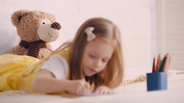 Selektive Fokussierung Von Teddybär Durch Kind Zeichnung Auf Bett — Stockvideo