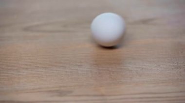 cropped view of man spinning egg on table