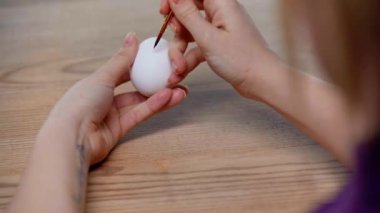 cropped view of woman painting easter egg 