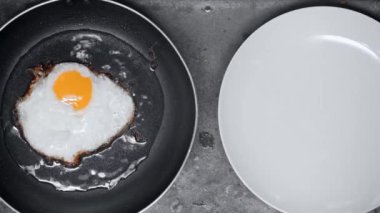 fried egg on frying pan near plate