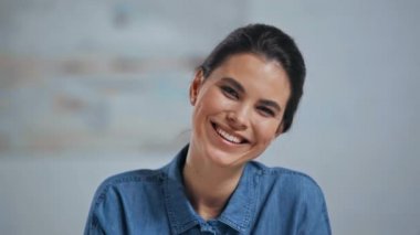 Mutlu kadın gülen ve kameraya bakıyor