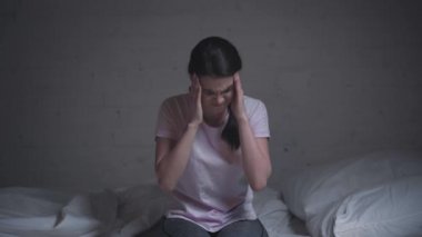 Geceleri başı ağrıyan genç bir kadın.