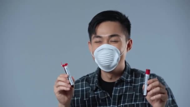 Asiatisk Man Dansar Med Provrör Med Coronasvirus Bokstäver Isolerade Grå — Stockvideo