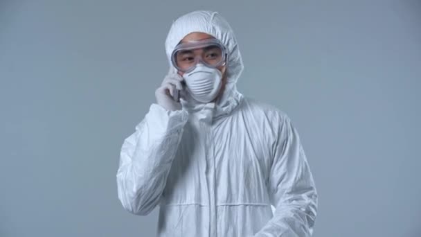 Asian Scientist Protective Suit Talking Smartphone Isolated Grey — Stock Video