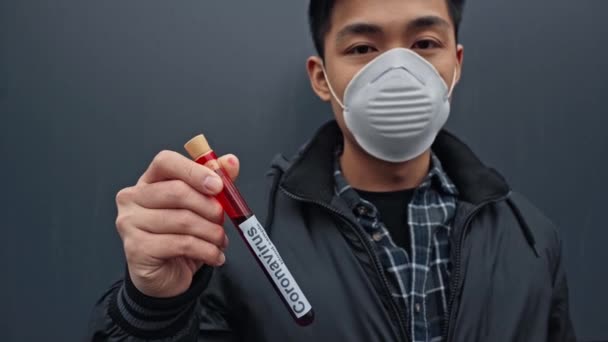 Asian Man Medical Mask Holding Sample Coronavirus Lettering Grey — 비디오