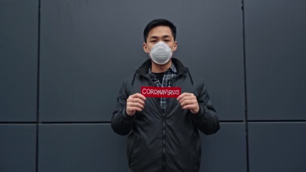 Ung Asiatisk Man Som Håller Papper Med Coronavirus Bokstäver — Stockvideo