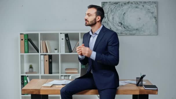 Knappe Zakenman Aanraken Jas Zitten Het Bureau Met Gekruiste Armen — Stockvideo