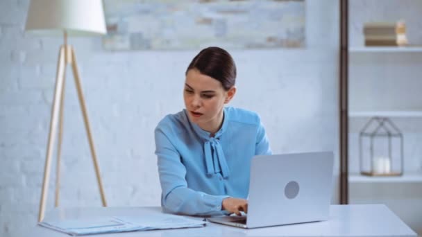 兴奋的女商人在笔记本电脑上打字 在办公室打手势 — 图库视频影像