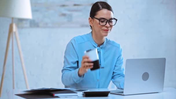 魅力的な実業家がコーヒーを飲みノートパソコンを使って — ストック動画
