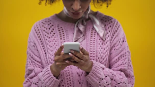 黄色で隔絶されたスマートフォンでアフリカ系アメリカ人の少女を切り取り — ストック動画