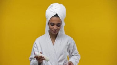 Afrikalı Amerikalı kız sarı deodorant püskürtüyor. 