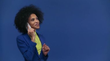 Mutlu Afro-Amerikalı kız mavi telefonda akıllı telefonla konuşuyor.