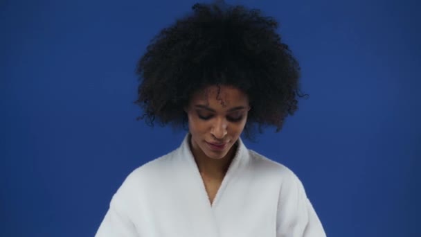 African American Woman Applying Face Cream Isolated Blue — Stock Video