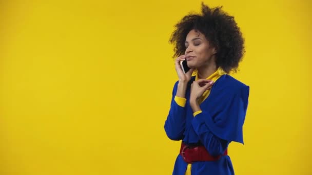 アフリカ系アメリカ人の女性が黄色で隔絶されたスマートフォンで — ストック動画