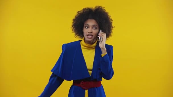 怒っているアフリカ系アメリカ人の少女が黄色で隔絶されたスマートフォンで — ストック動画