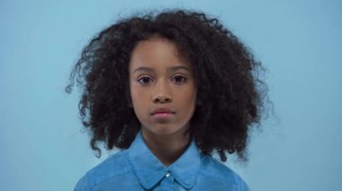 Sevimli Afrikalı Amerikalı çocuk mavi kameraya bakıyor. 